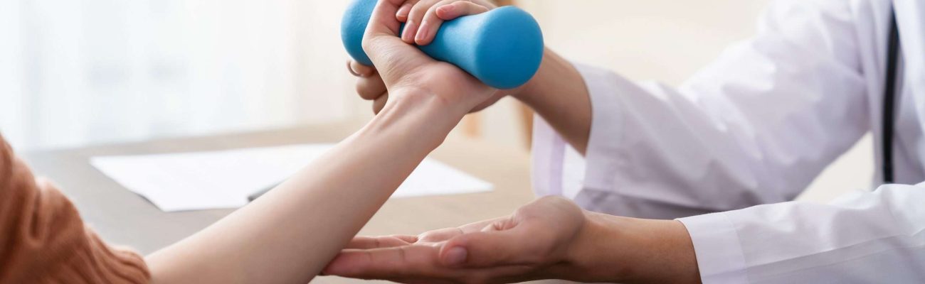 The doctor performed hand physical therapy for the patient with dumbbells.